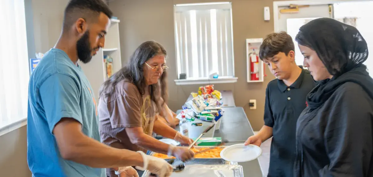 Staff member serving food to residents at event