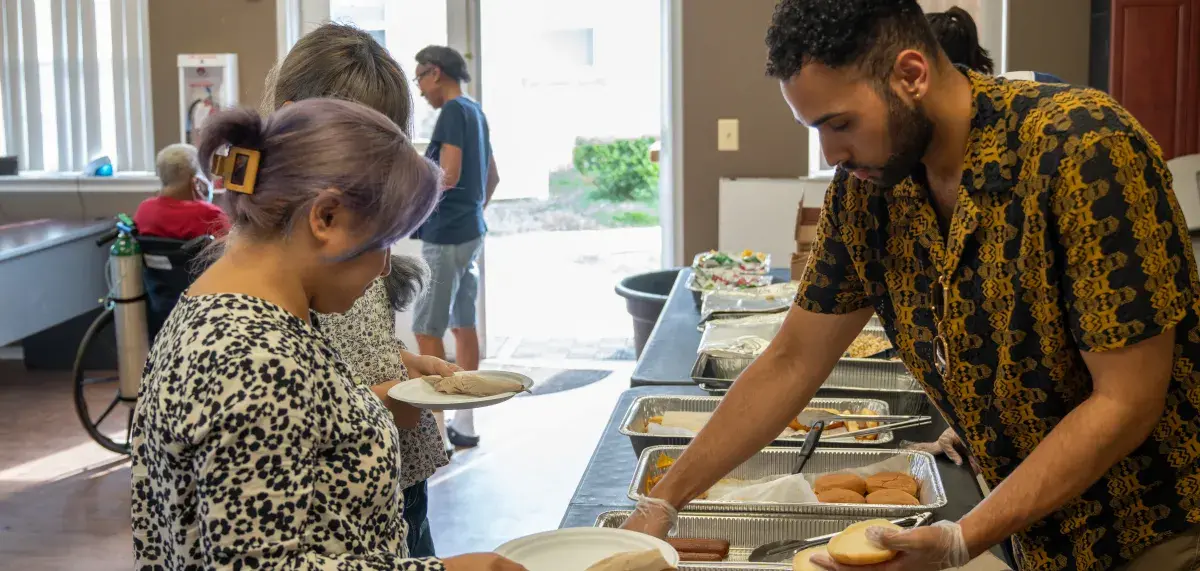 Individual being served food in a community room