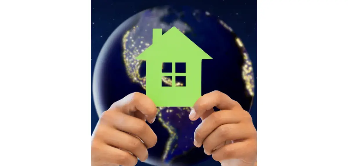Hands holding house cutout with earth in background