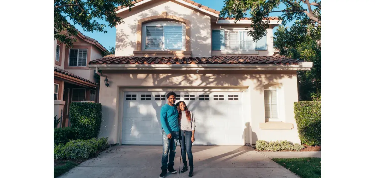 Young couple smiling outside of their new home