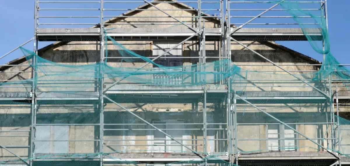 Older residential building covered in scaffolding
