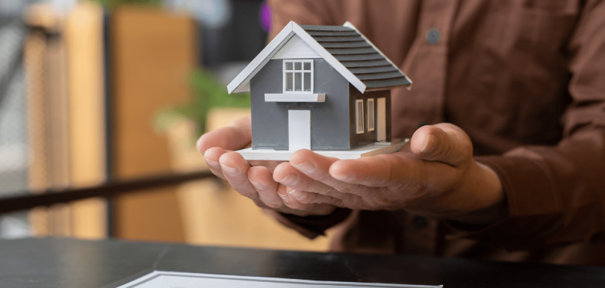 Hands holding a scale model of a house