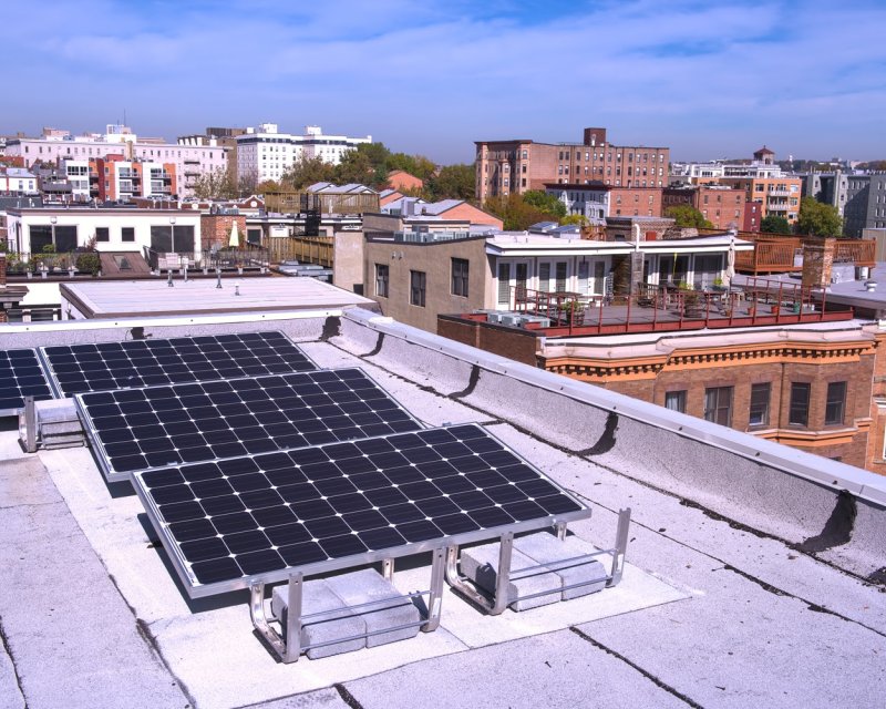 Roof with solar panels and view of city skyline