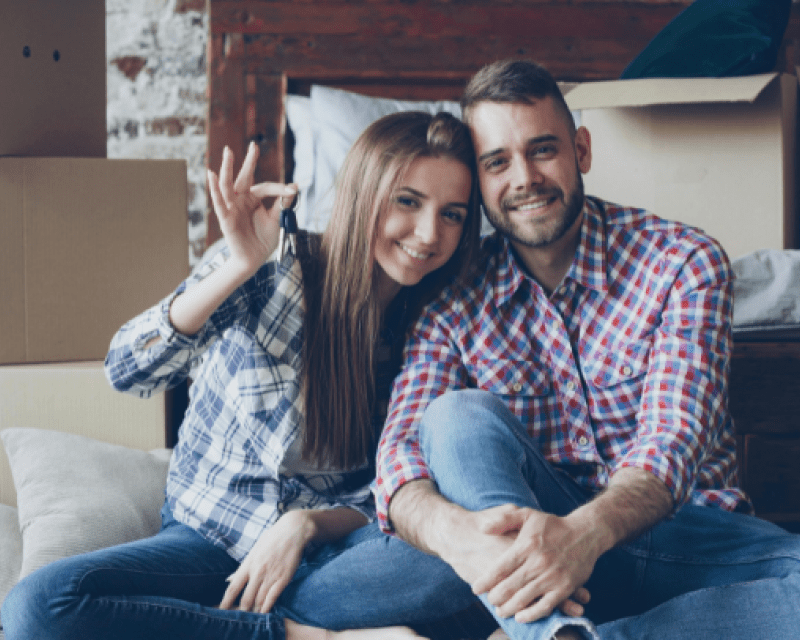 Stock image of couple smiling, holding keys