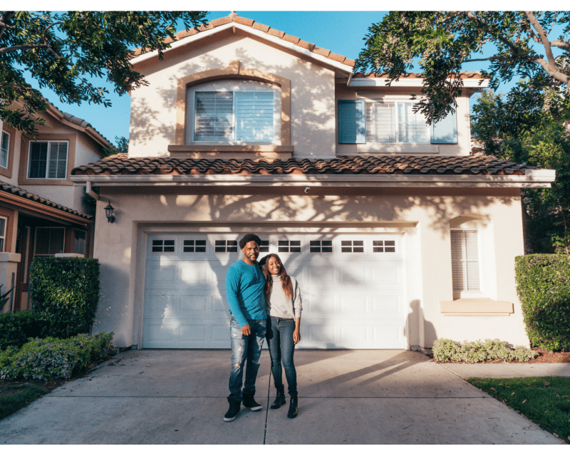 Young couple smiling outside of their new home