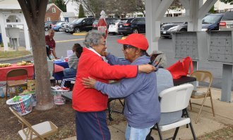 Two elders of color sharing a joyful embrace.