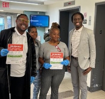 Four smiling tenants show off paper indicating they participated in an NHT sponsored program