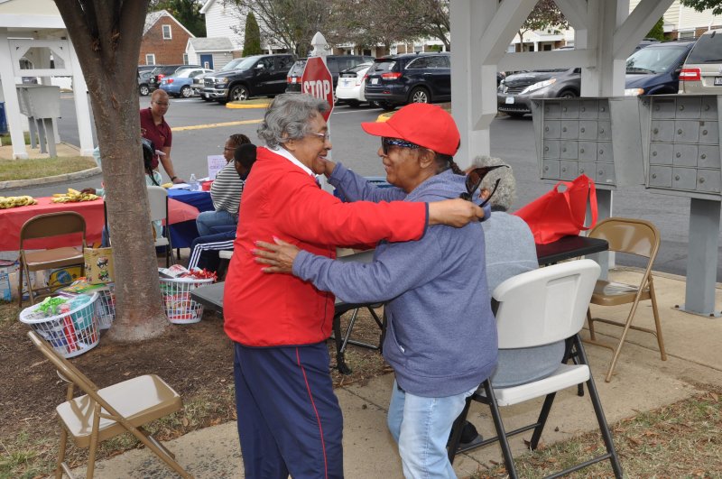 Two older women hugging at a community event